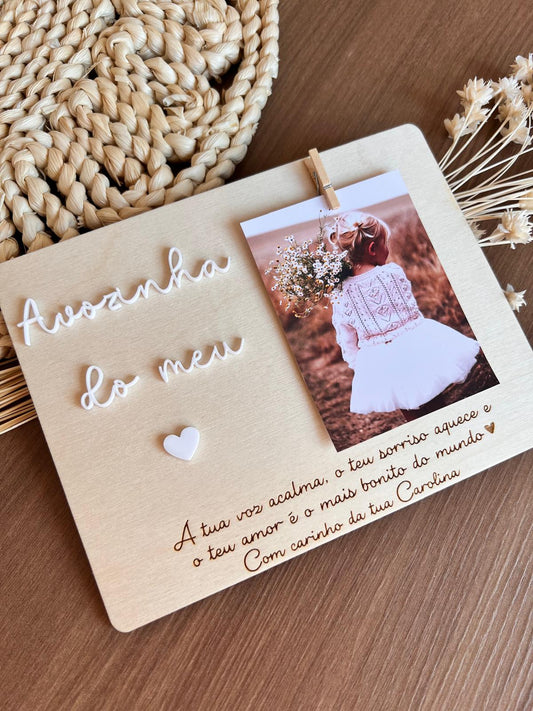Moldura personalizada em madeira para avó com frase gravada e aplique em acrílico branco, acompanhada de fotografia com mola de madeira.
