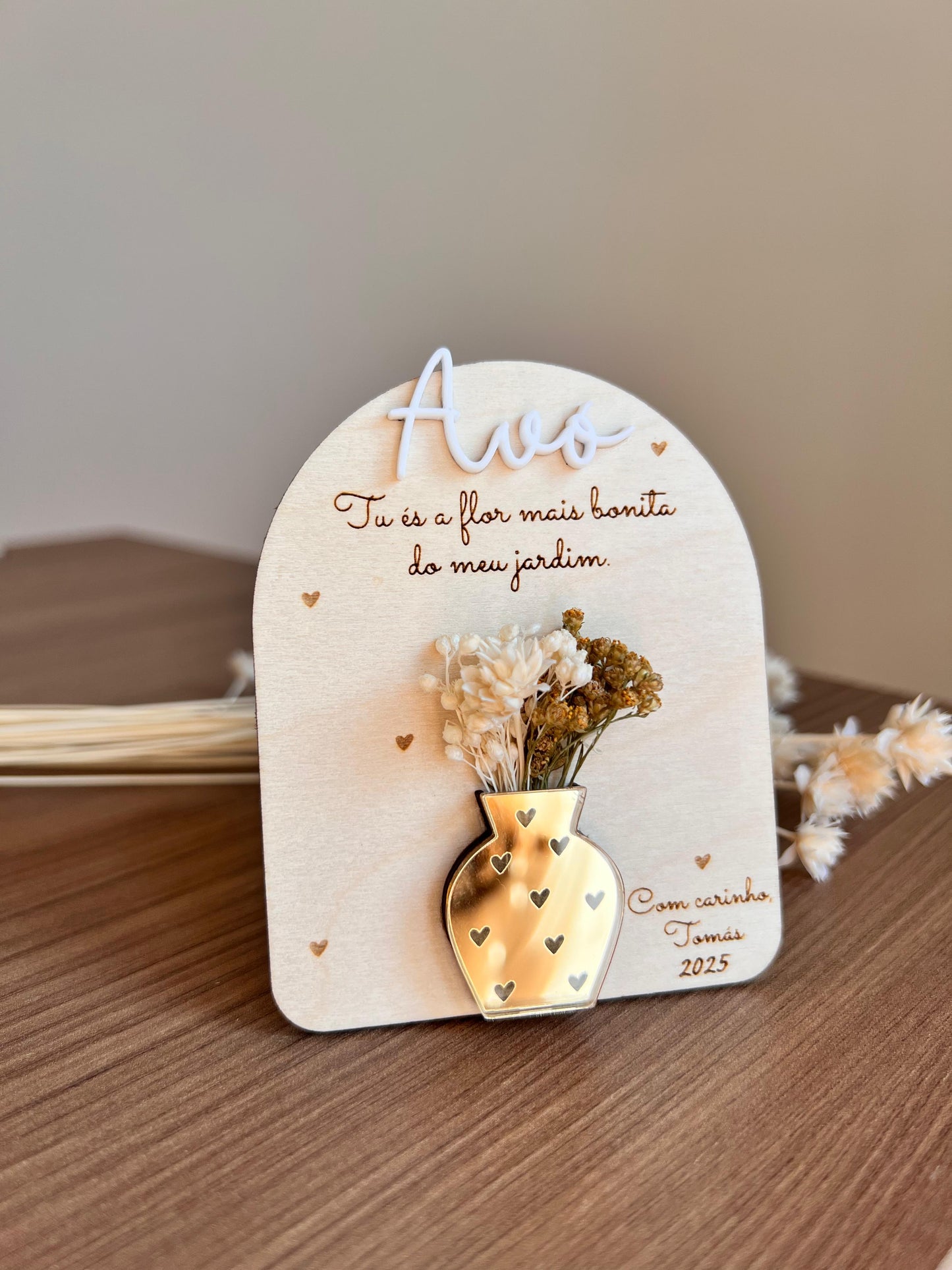 Placa decorativa em madeira com vaso dourado em acrílico e flores secas, personalizada com mensagem para a avó.