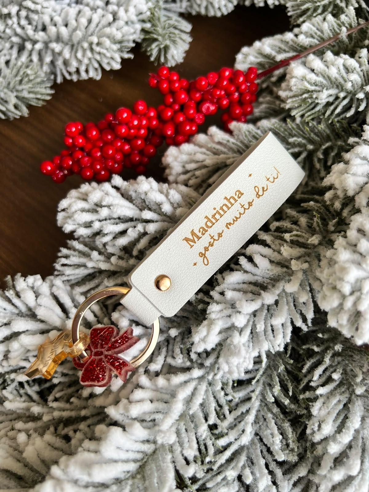 Chaveiro para madrinha personalizado em pele branca de 12x2 cm com mini pendente de estrela dourada com o nome Olívia e laço de acrílico vermelho brilhante