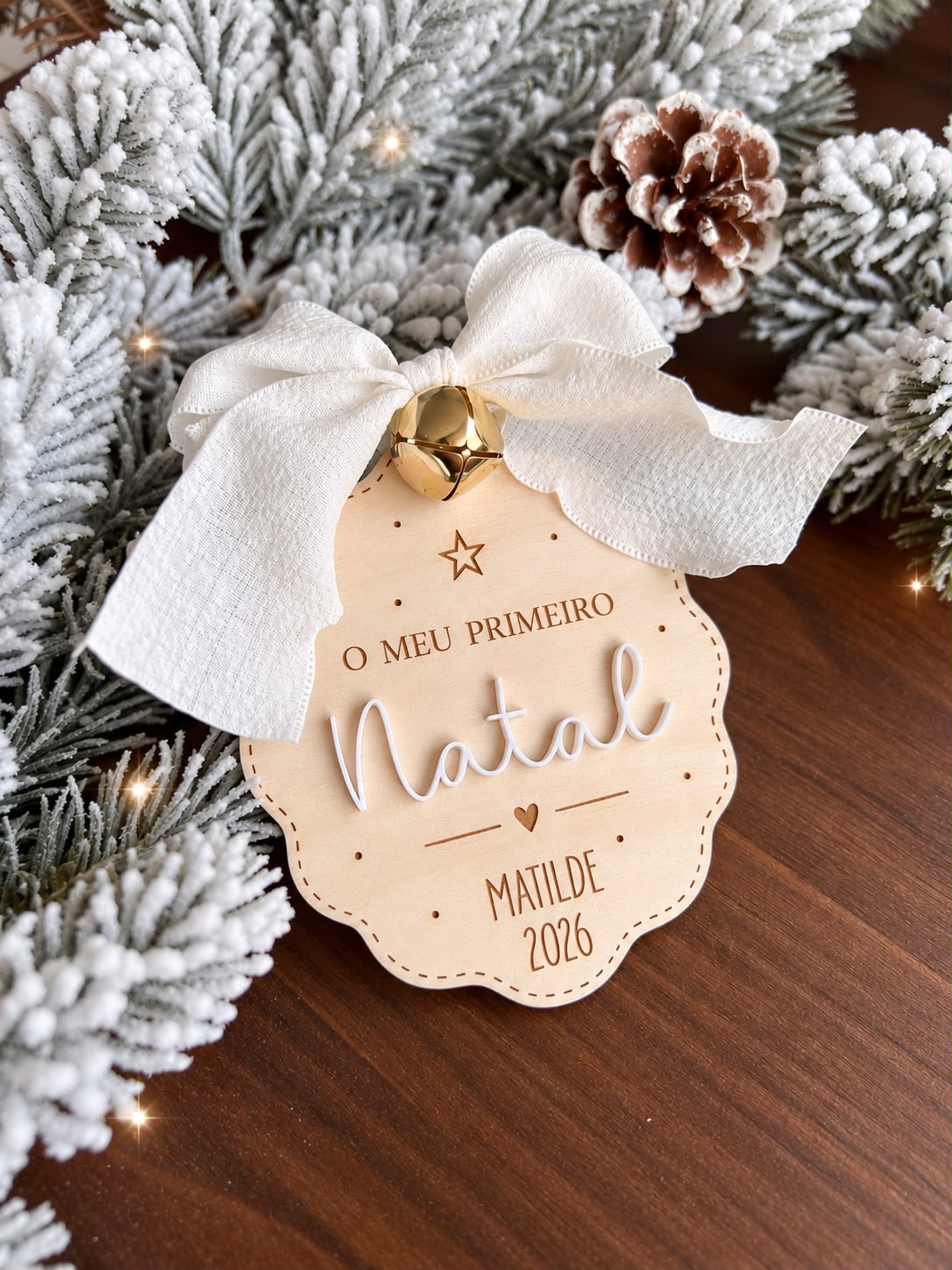 Bola de Natal personalizada em madeira de bétula com a gravação O Meu Primeiro Natal, com laço branco e guizo de 15mm.