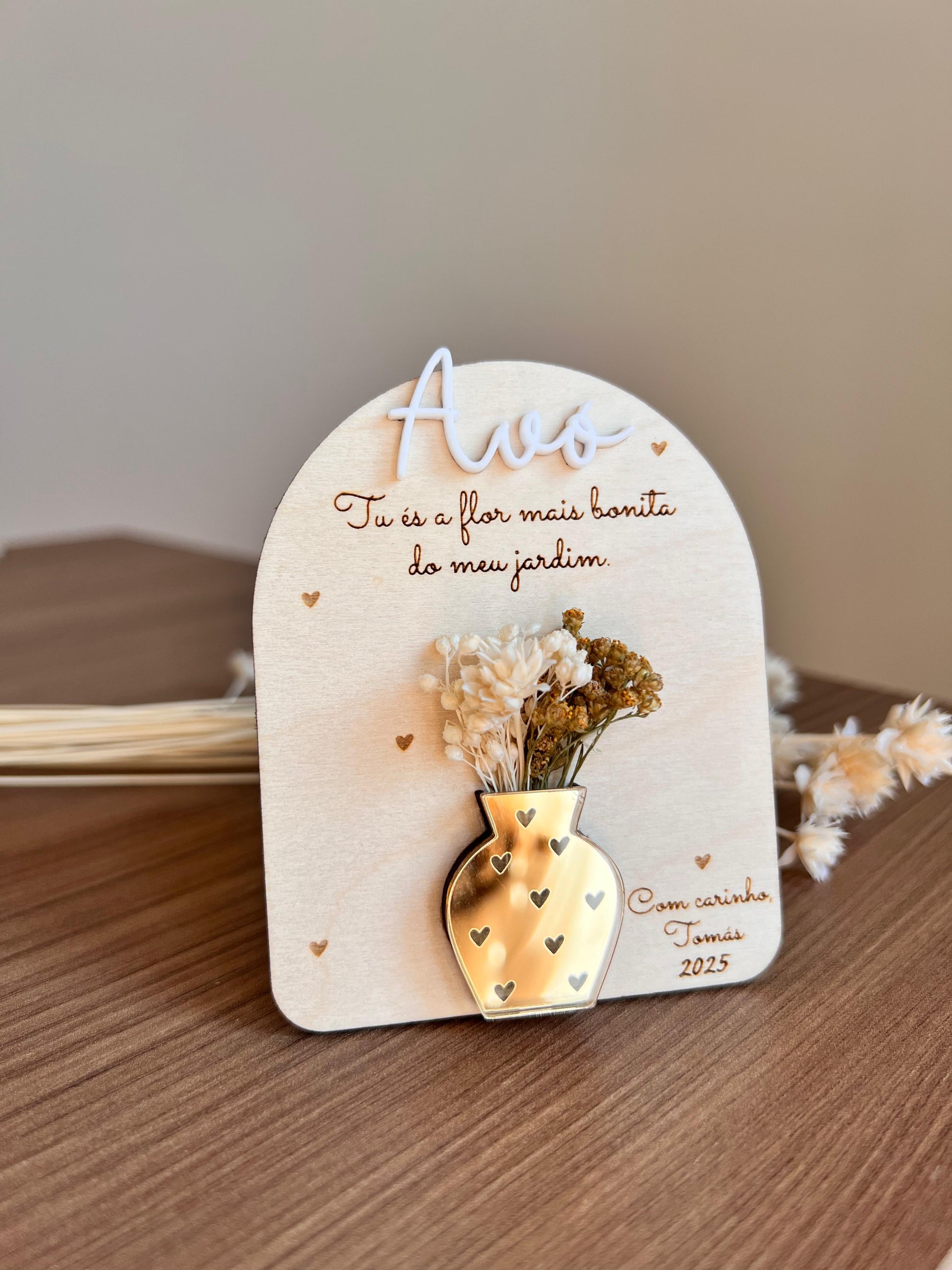 Placa decorativa em madeira com vaso dourado em acrílico e flores secas, personalizada com mensagem para a avó.
