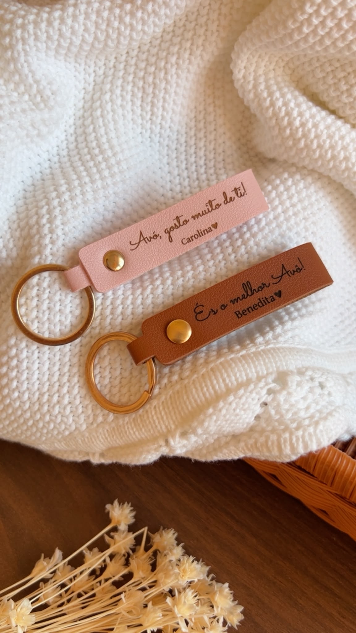 Porta-chaves personalizados em pele sintética rosa pastel e castanha camel com gravações a laser Avó gosto muito de ti e És o melhor Avô sobre manta branca texturada.